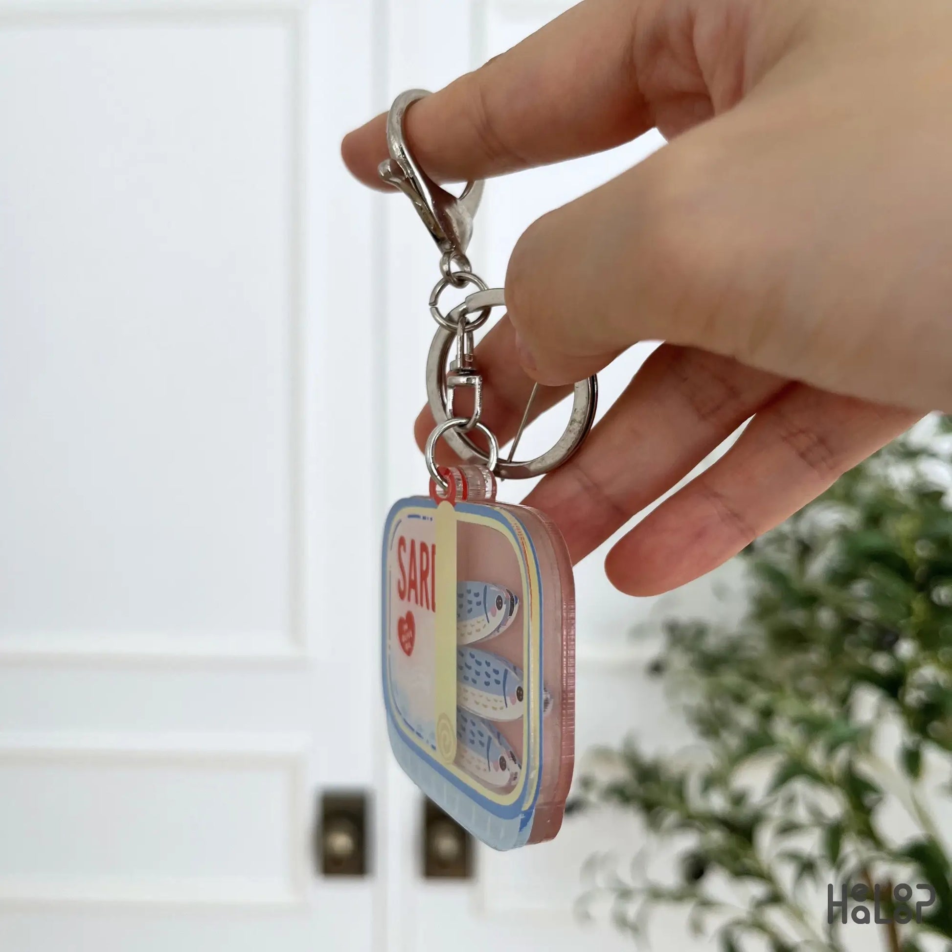 Side view of Sardine Shaker Keychain showing layered acrylic construction and fish charms inside.