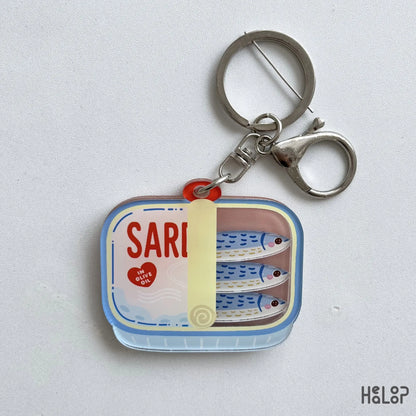 Sardine Shaker Keychain featuring three moving fish charms inside a colorful tinned fish design with silver keychain hardware.