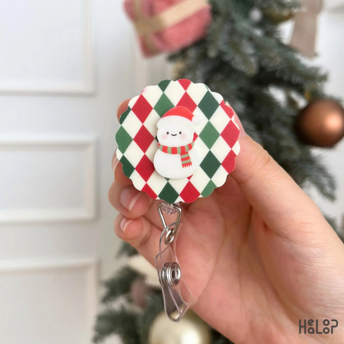 Cute snowman holiday badge reel featuring a red, green and cream argyle Christmas background
