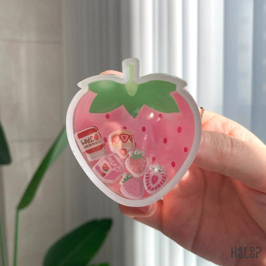 Detailed close-up of strawberry shaker phone grip with kawaii floating fruit and milk charms