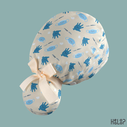 Angled rear view of the HEALOOP Surgical Ponytail Scrub Cap, highlighting the playful surgery-themed print, cream-colored ribbon, and spacious pouch designed for long hair.