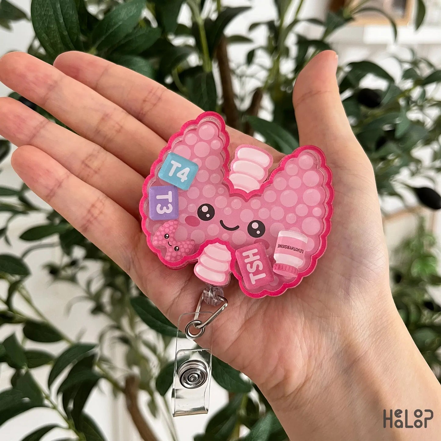 Detailed view of Healoop Thyroid Shaker Badge Reel with adorable smiling thyroid and endocrine-themed shaker charms.