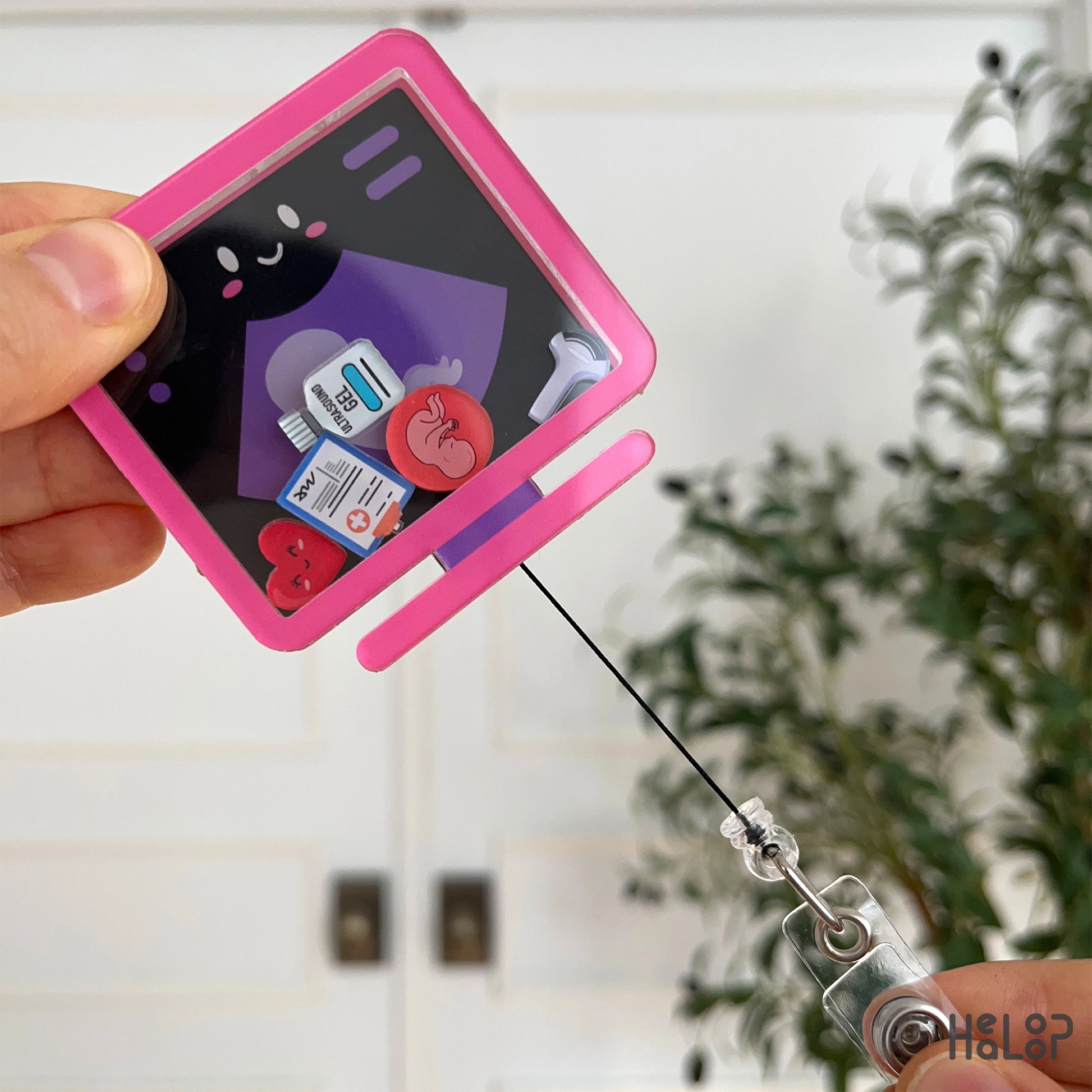 Retractable ultrasound badge reel extended to show cord.