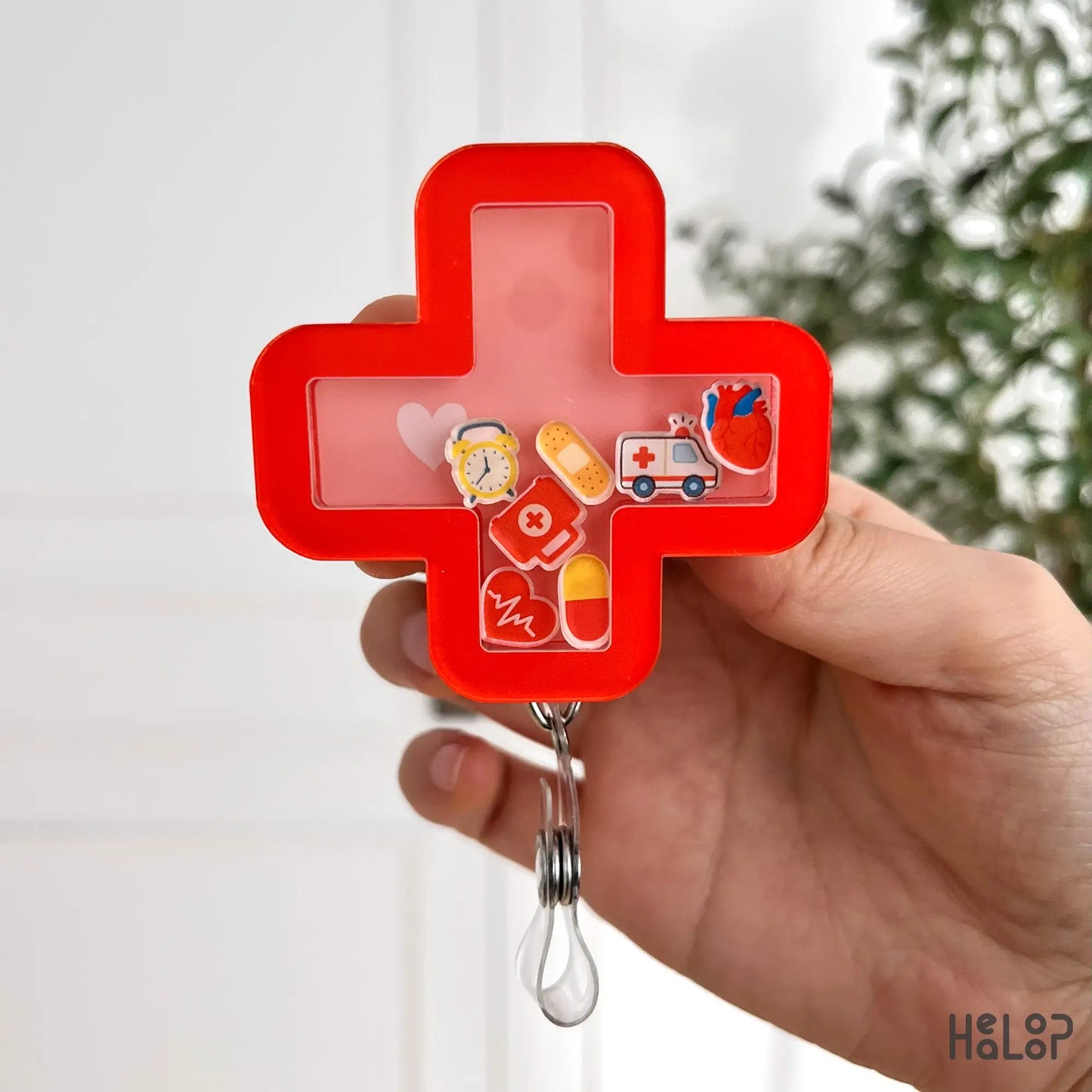 Urgent care shaker badge reel with red cross shape, floating ambulance, and pill charms
