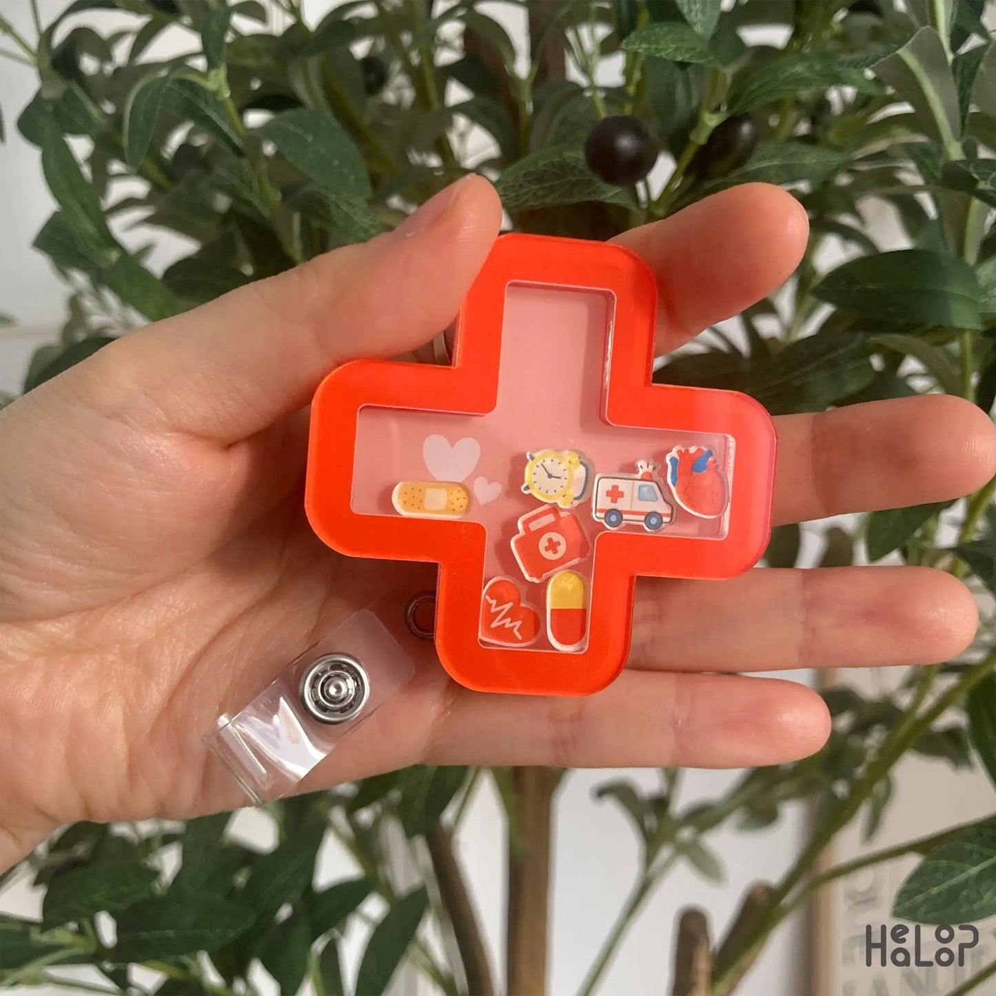Urgent Care Shaker Badge Reel – red cross design with cute medical charms held in hand