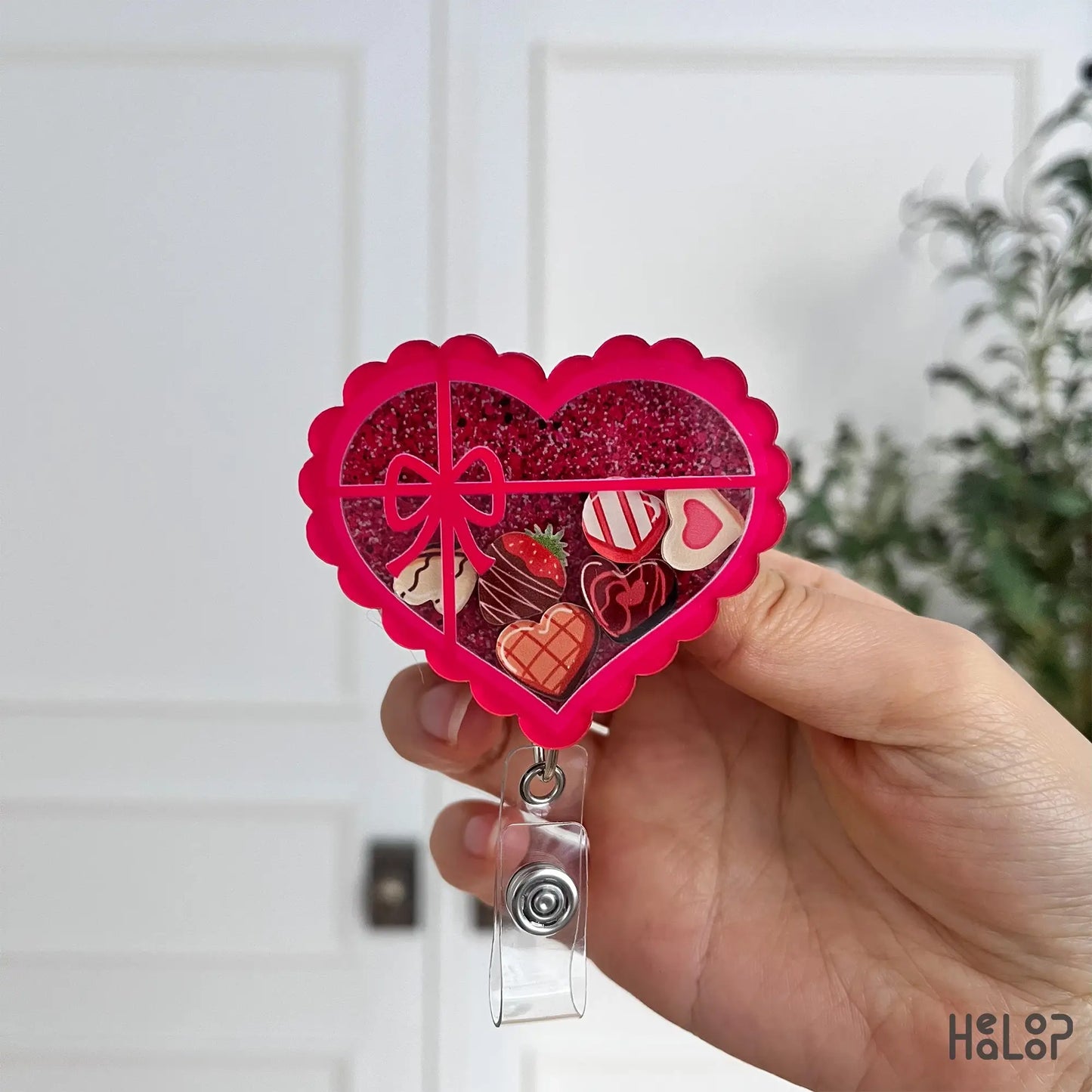 Vibrant heart chocolate shaker badge reel with glitter top and candy charms inside