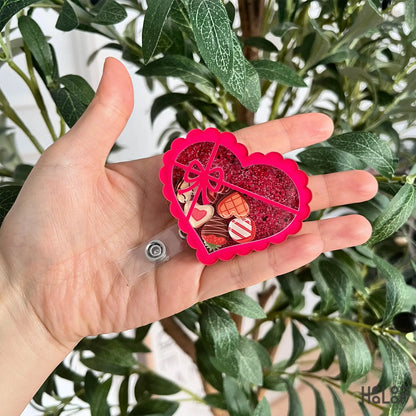 Heart chocolate box shaker badge reel featuring glitter and mini chocolate charms