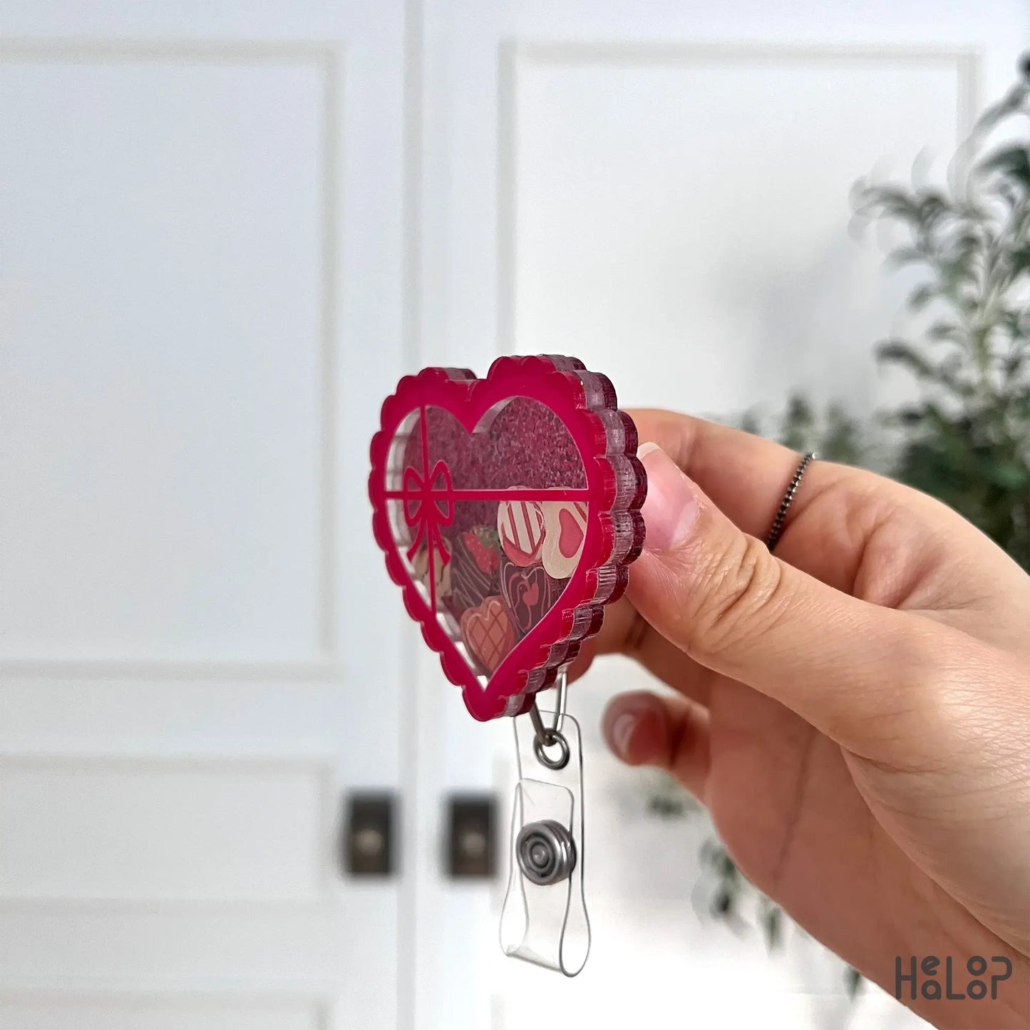 Side profile of pink heart-shaped chocolate shaker badge reel for nurses and healthcare workers