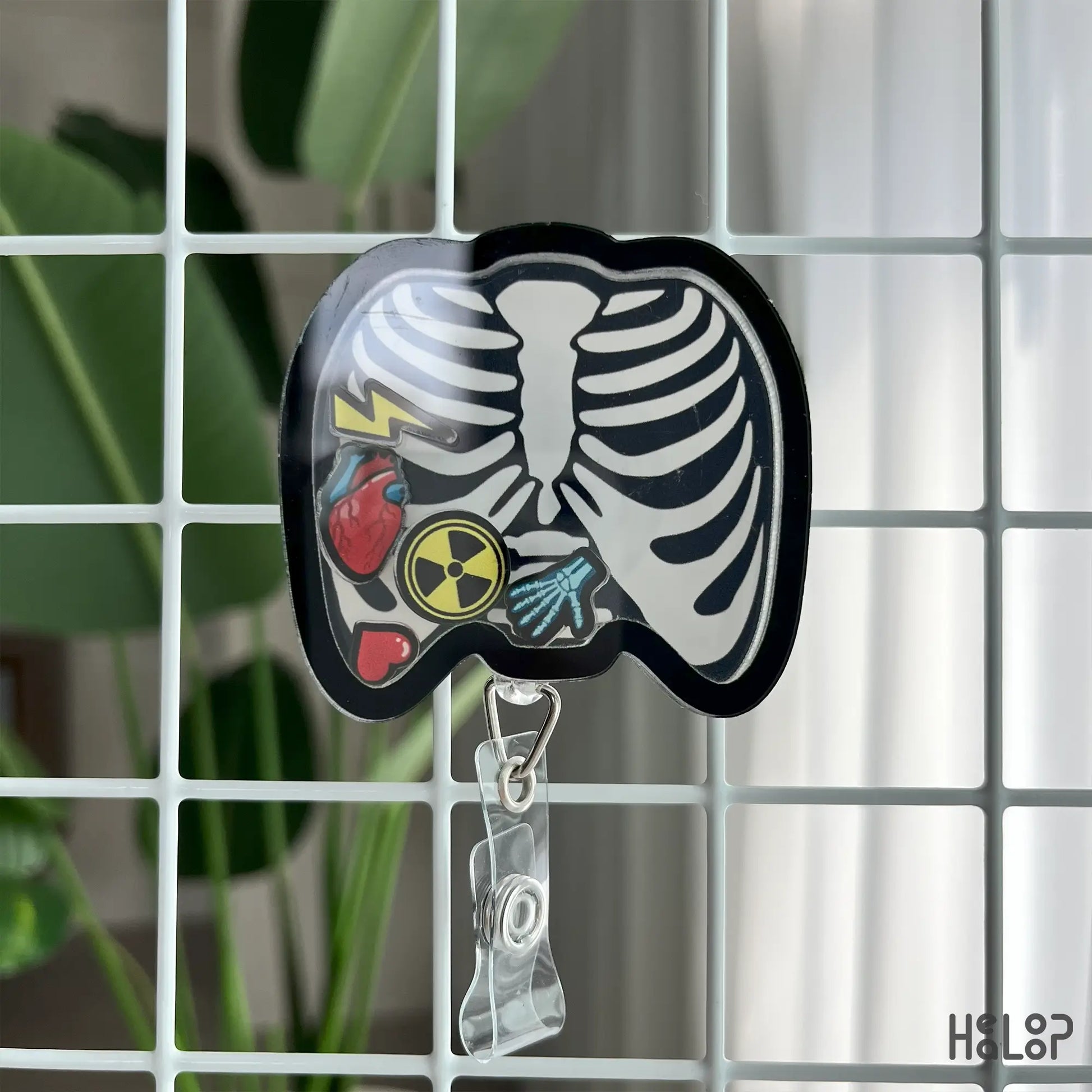 X-Ray tech badge reel with ribcage design and fun shaker charms, perfect for nurses and rad techs